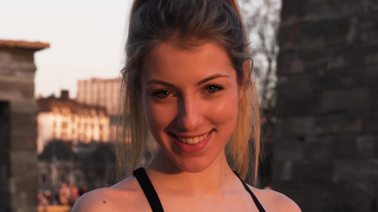 Happy Beautiful Woman Smiling At Camera In Urban Scenery, Close Up