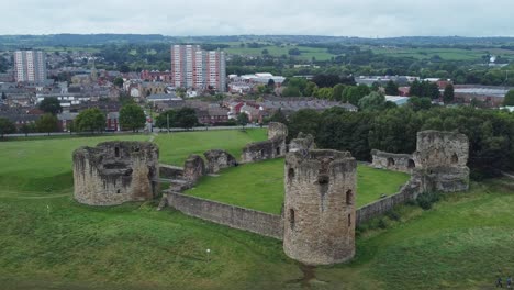 Flint-castle-Welsh-medieval-coastal-military-fortress-ruin-aerial-view-slow-rising-tracked-shot