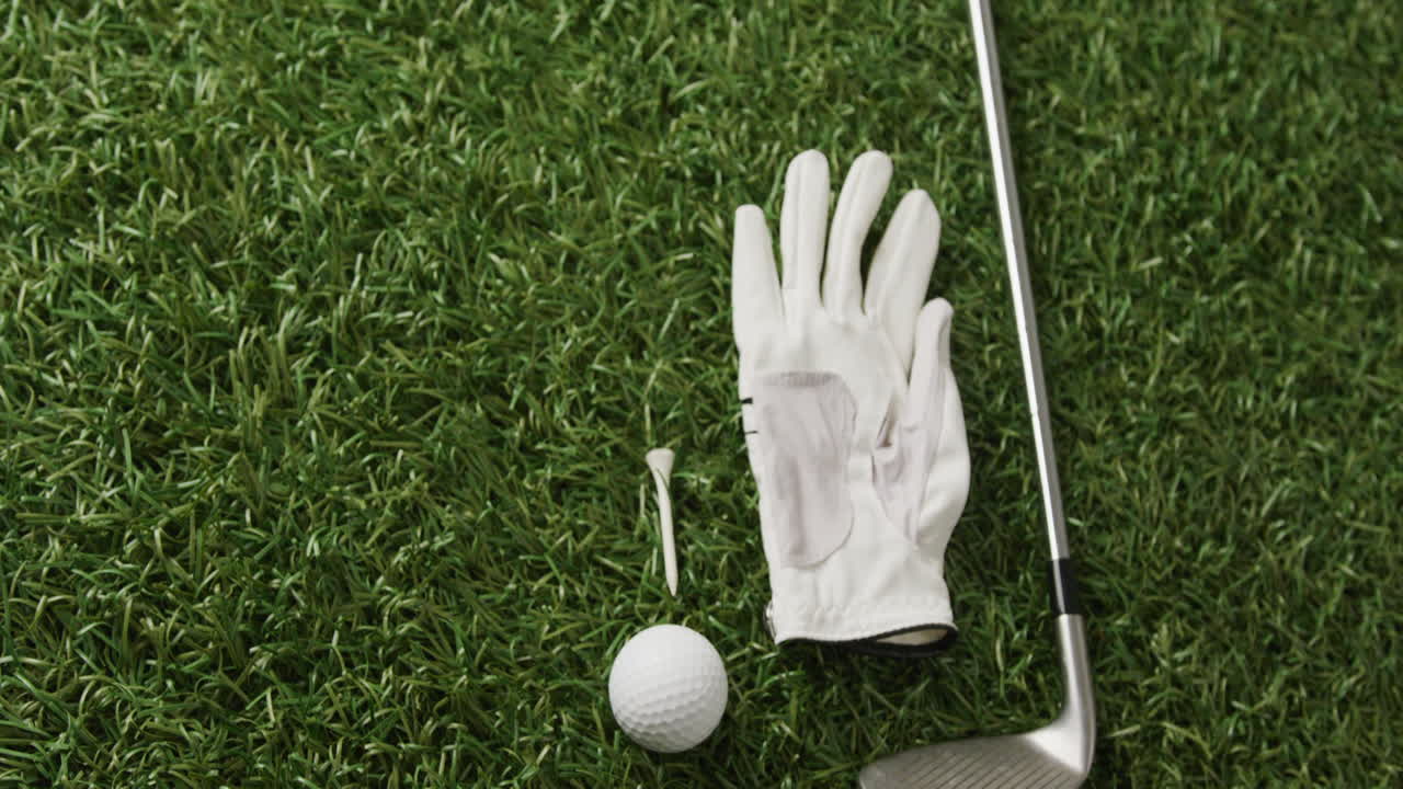 Close-up de taco de golfe, bola e luva na grama, espaço para texto, em câmera lenta