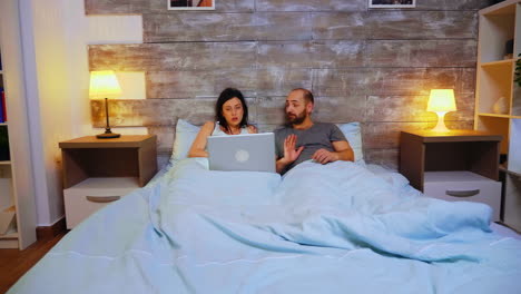 zoom en la toma de la pareja acostada en la cama bajo la manta