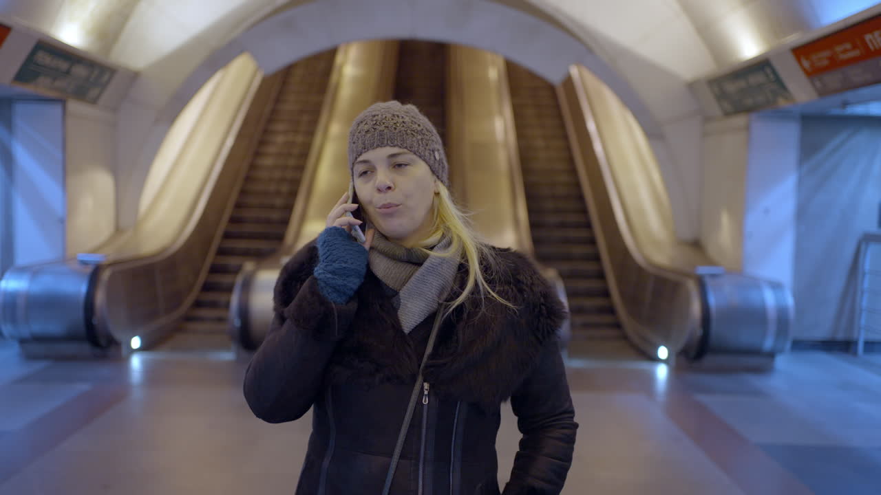 Woman talking on her phone in a subway station