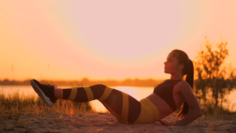 Fitness-woman-doing-crunches-at-the-beach.-Fitness-woman-doing-crunches-exercise-workout-towards-the-beach.-Female-fit-athlete-training-abdominal-midsection