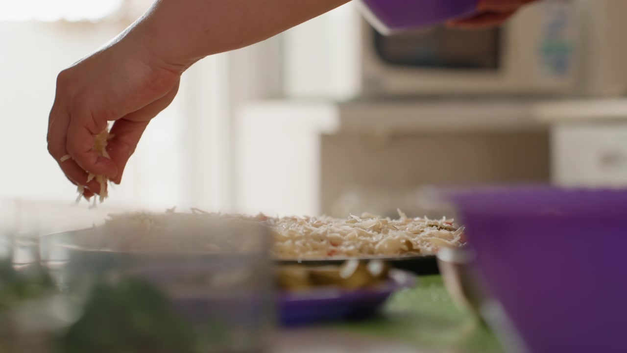 Low-angle close-up of hand scattering topping over homemade pie resting on wire cooling rack, with falling crumbs, warm sunlight, soft blur, and gentle kitchen motion after baking, with hand
