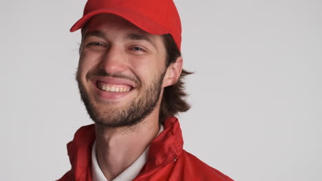 caucasian delivery man in front of camera on white background.