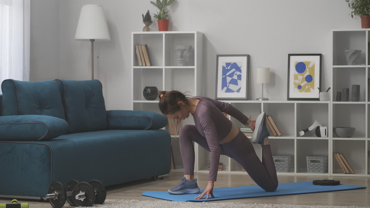 joven mujer deportiva está estirando los músculos de los muslos estiramiento entrenamiento en el hogar deporte y estilo de vida saludable cuidado de la belleza del cuerpo