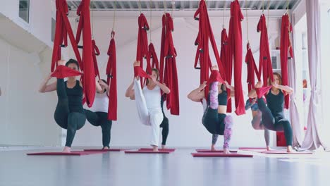 concentrated women practice warrior aerial fly yoga asana