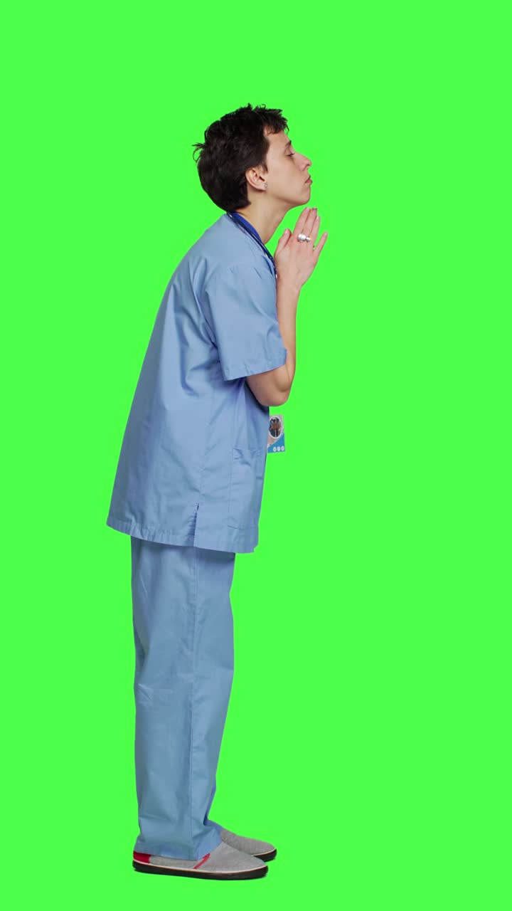Profilo di un assistente medico speranzoso che prega per avere fortuna su greenscreen