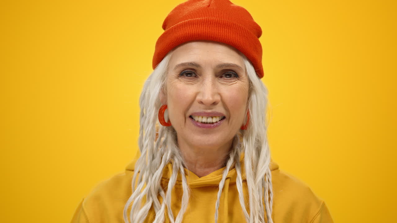 아름다운 여성은 실내에서 카메라를 찾고 있습니다. 편안한 여성은 스튜디오에서 얼굴을 올립니다.