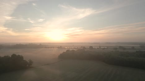 misty sunrise over farmland