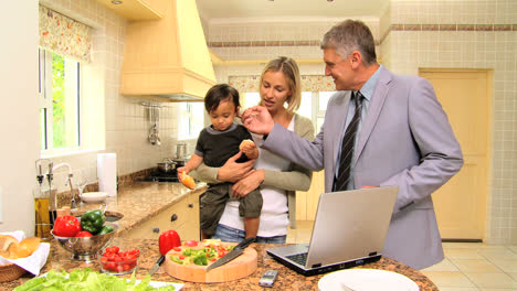parents talking in kitchen while mother holds baby
