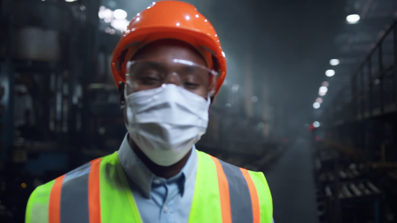 Masked supervisor looking camera at digital energy production factory.