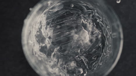 Closeup-hands-put-ice-cube-into-mineral-water-glass.-Preparing-drinks-concept