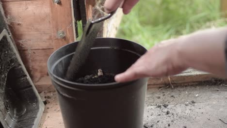 Gardener-preparing-plant-pots-in-wooden-shed