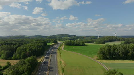 aerial view of a highway cutting through a lush green countryside