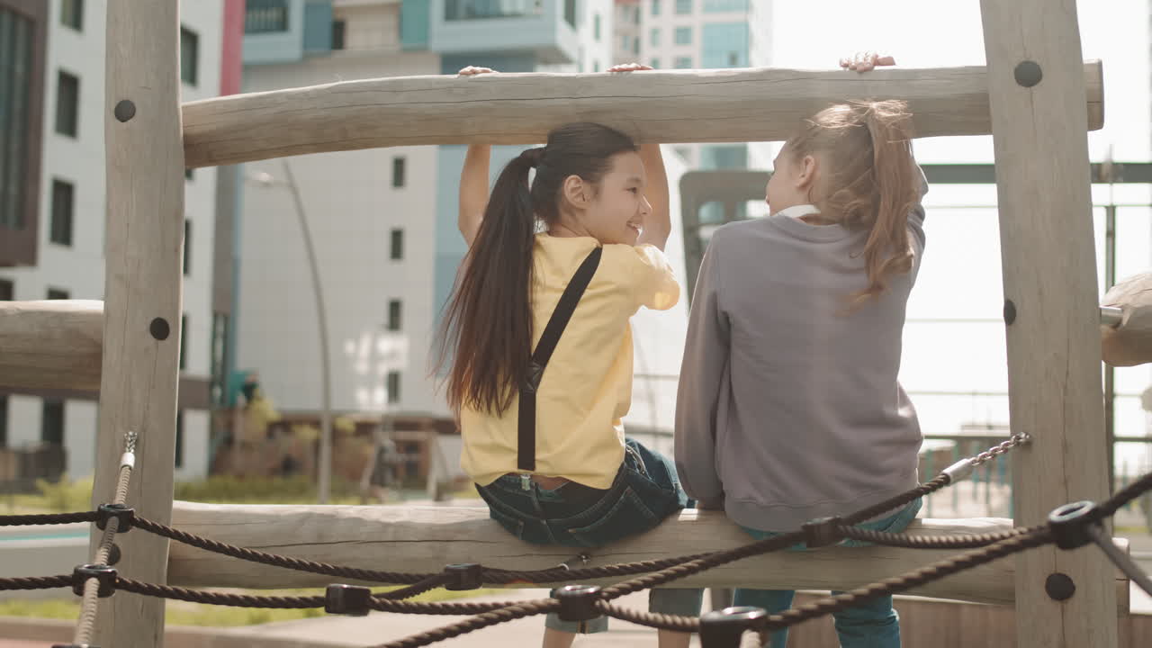 Rear View of School Girlfriends at Playground