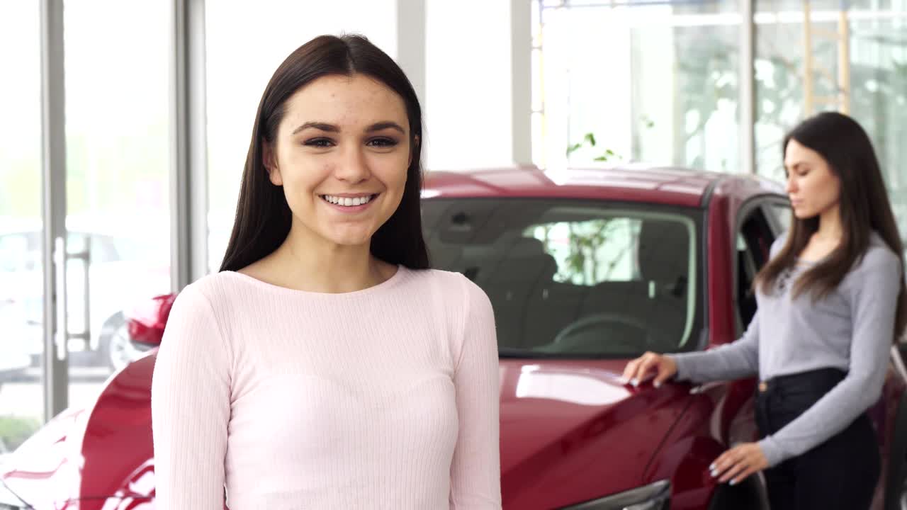 joven alegre mostrando los pulgares hacia arriba sosteniendo las llaves del coche