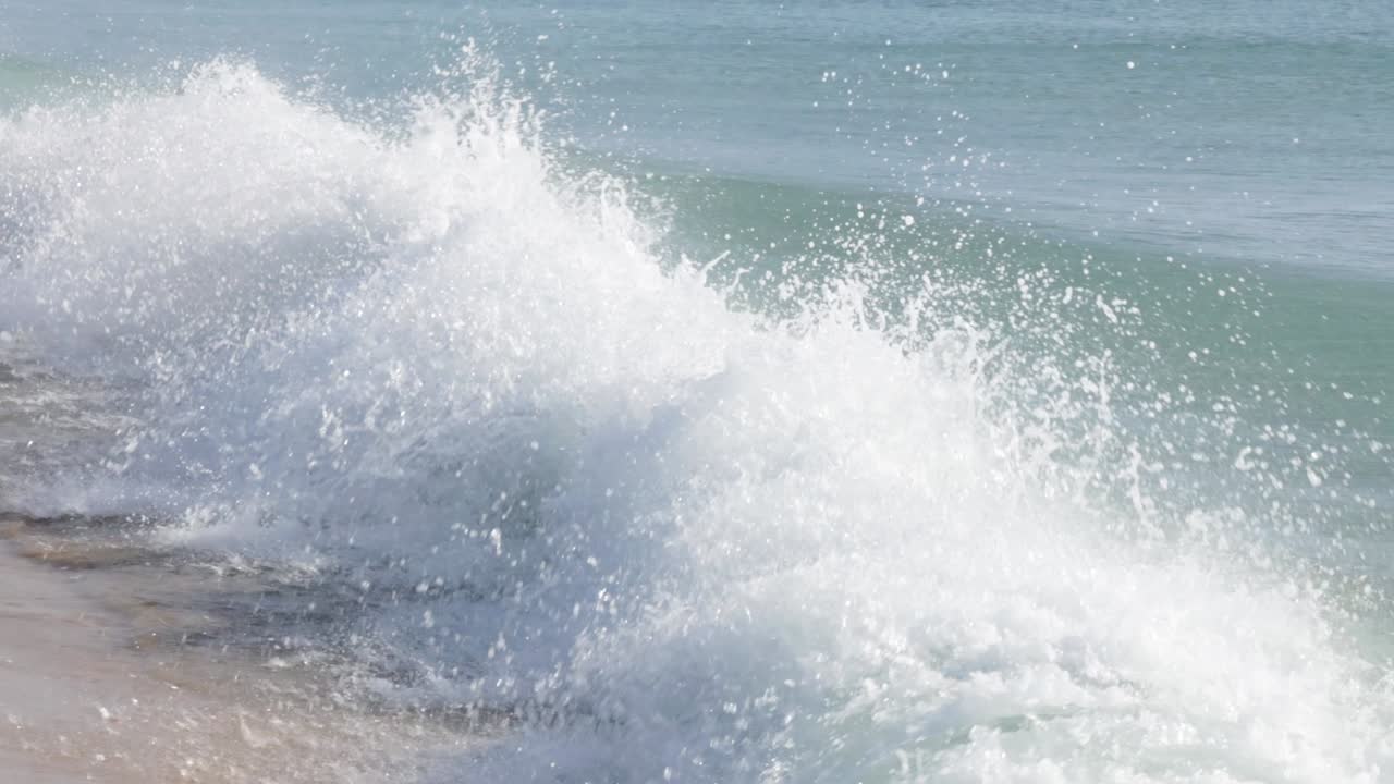 Aqua green blue powerful waves crashing in slow motion of sparkling water droplets at the wave crest, Trincomalee, Sri Lanka. Bay of Bengal Sea