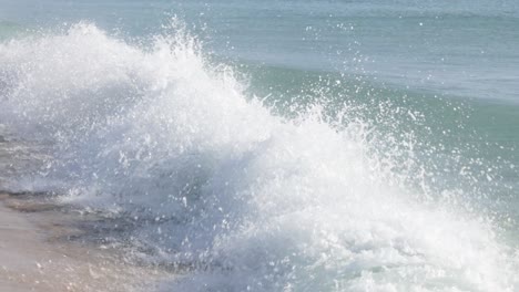 aqua green blue powerful waves crashing in slow motion of sparkling water droplets at the wave crest, trincomalee, sri lanka. bay of bengal sea