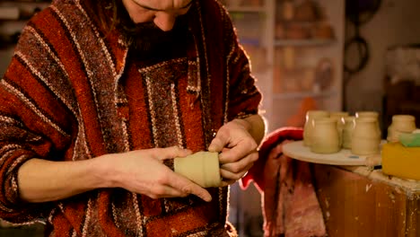 professional male potter making mug in pottery workshop