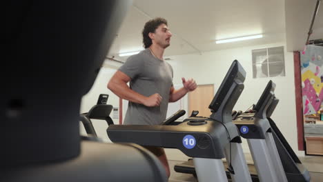 active man running on the treadmill of fitness club. - wide shot
