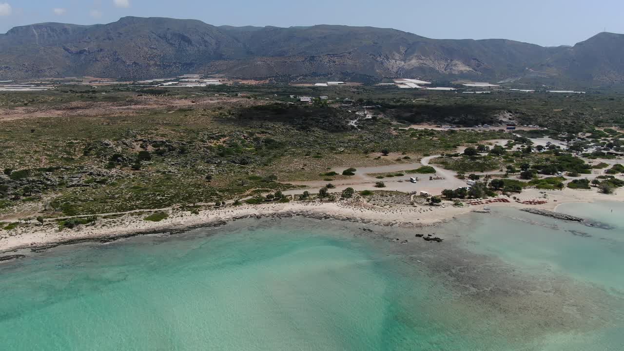 Elafonissi Beach lagoon in Crete Greece with coastline edge leading to the mainland, Aerial dolly in shot