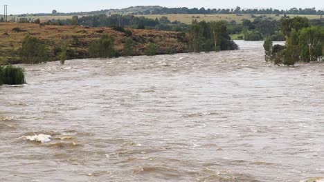 río de flujo rápido inundando río abajo, clima extremo, presa vaal sudáfrica