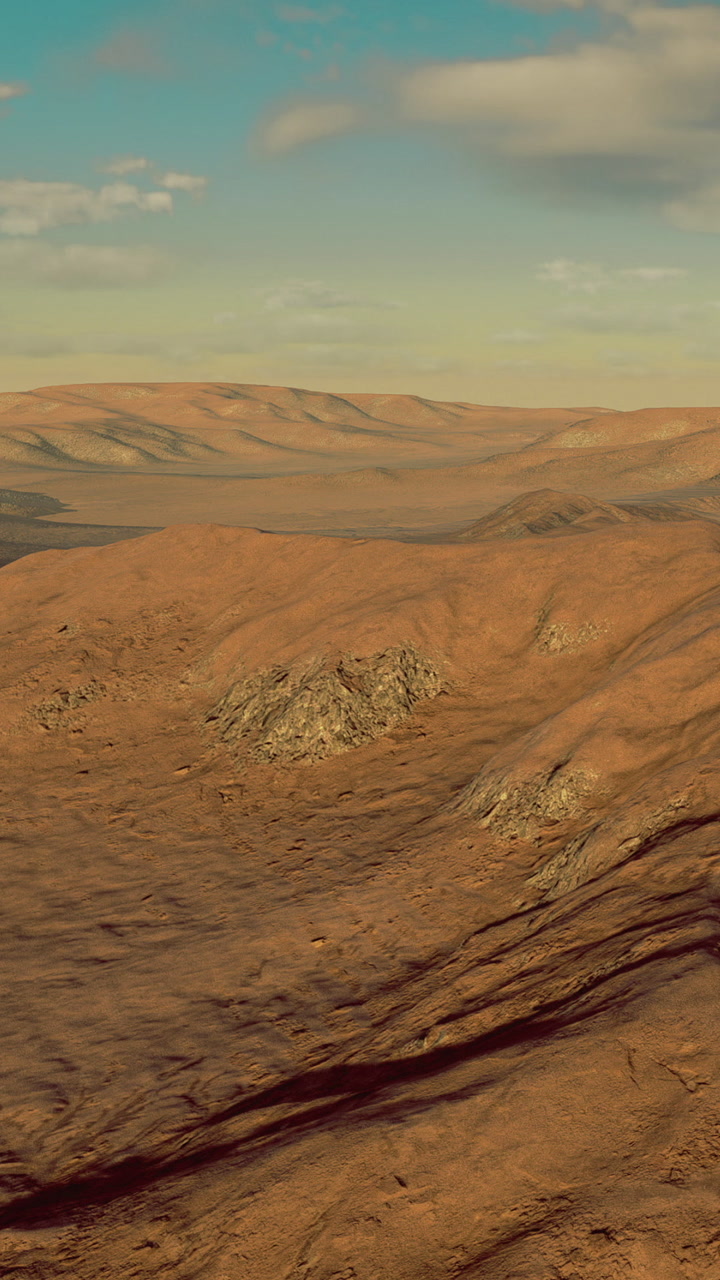 Desert landscape with rolling hills and rocky terrain under a blue sky