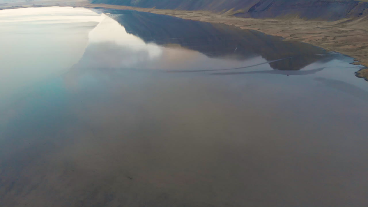 Stokksnes icy Icelandic ocean aerial view tiling up to mirrored reflection of Vestrahorn mountain, Höfn