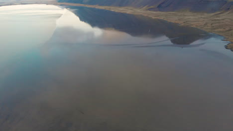 stokksnes icy icelandic ocean aerial view tiling up to mirrored reflection of vestrahorn mountain, höfn