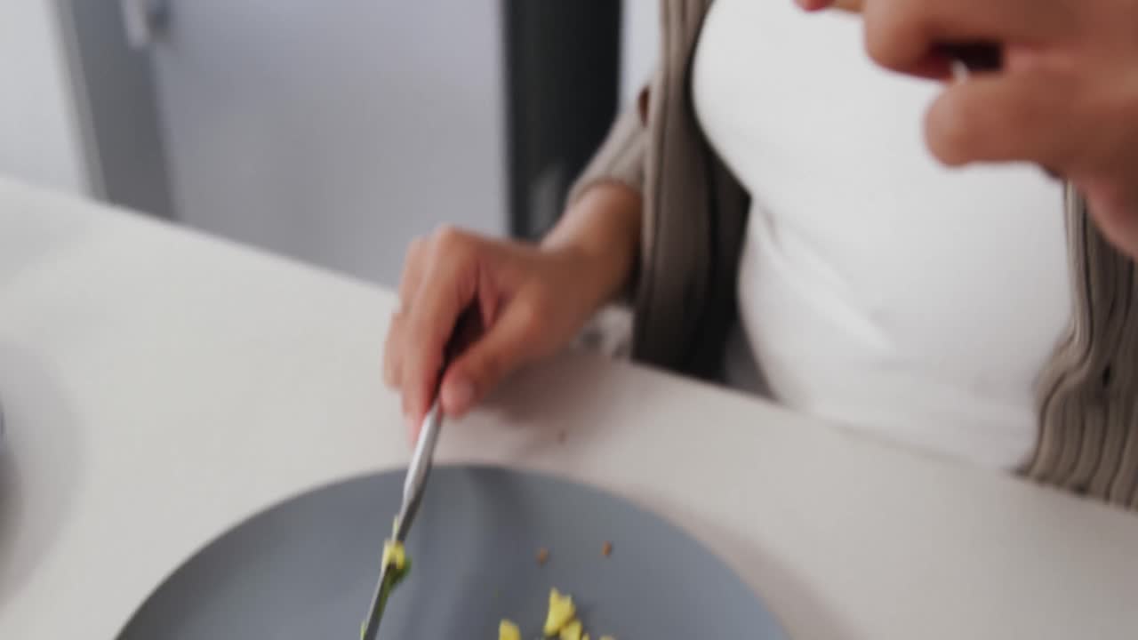 Žena snídá v kuchyni