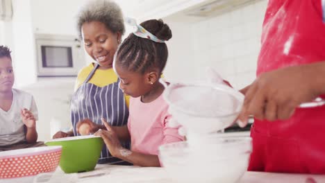 Felices-Abuelos-Afroamericanos-Horneando-Con-Nieta-Y-Nieto-En-La-Cocina,-Cámara-Lenta