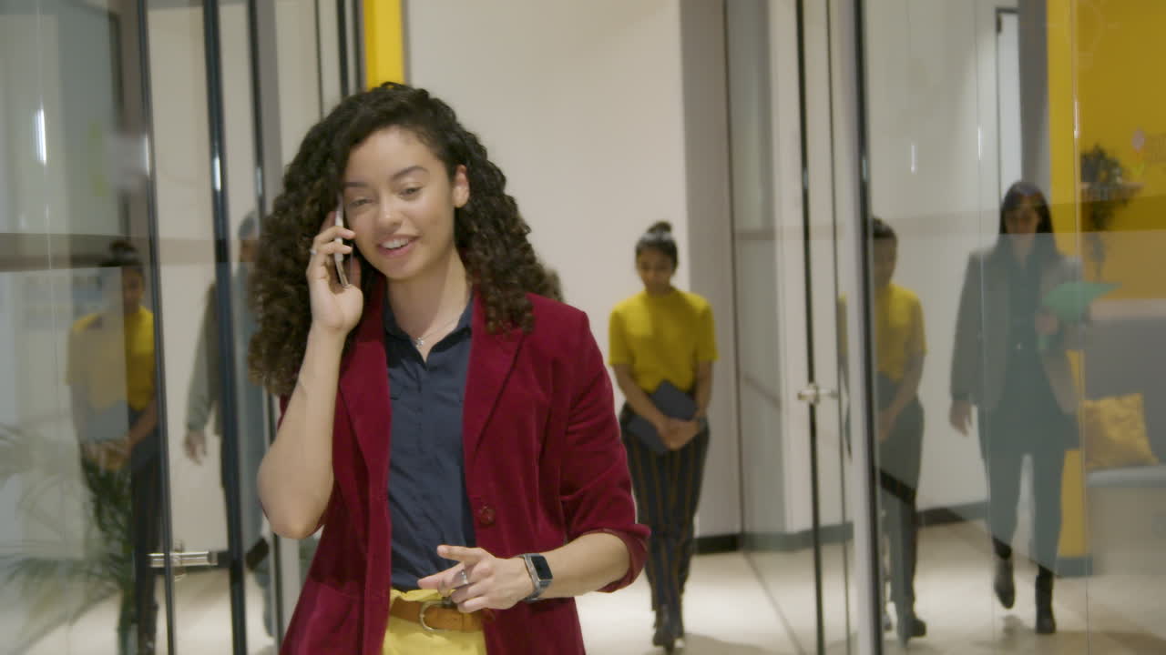 mujer de negocios hablando por teléfono inteligente en el corredor