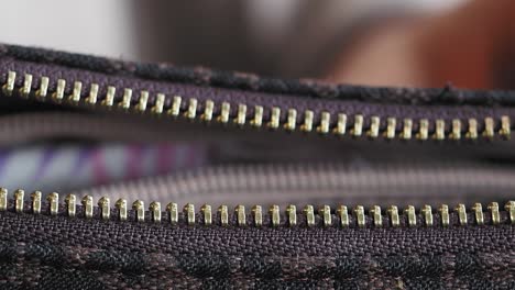 close-up view of a zipper on a dark brown purse