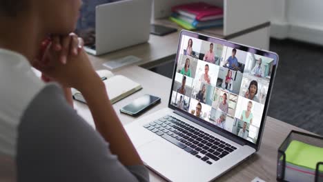 African-american-woman-having-a-video-conference-on-laptop-with-office-colleagues-at-office