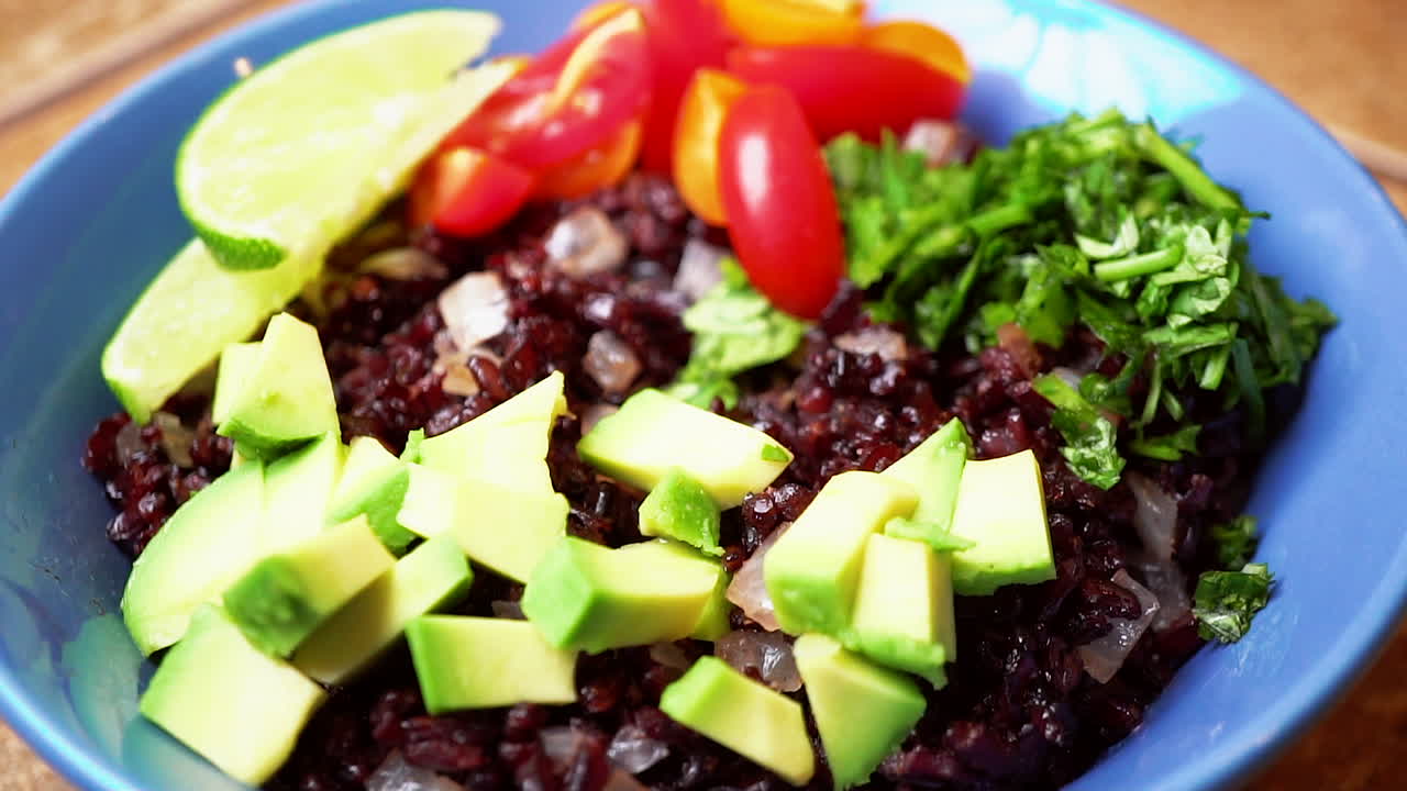 ensaladera casera de proteínas con arroz negro, aguacate, tomates y albahaca - delicia vegetariana vegana