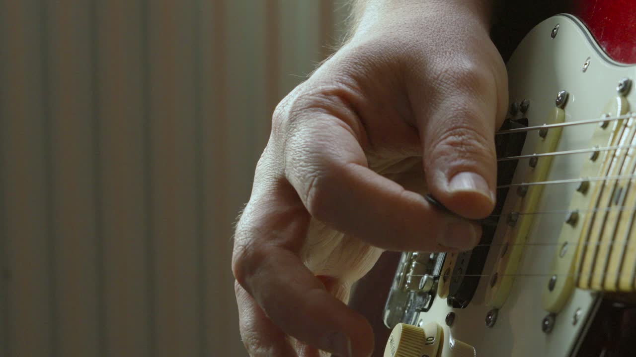 Close-up of Hand Playing Electric Guitar with a Pick