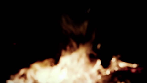 intentional blur: fiery violent flames from a campfire burning, intense fire in slow motion against a dark night, bad dream color grading