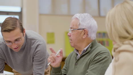 senior people having class with teacher in library