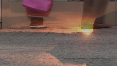 composite video of sunset sky against low section of people walking