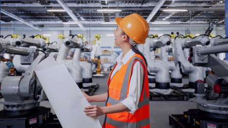 ingeniera revisando planos en una instalación de fabricación de robótica