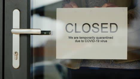 Business-Owner-Hangs-On-Door-Announcement-Of-Closure-Due-To-Coronavirus-Quarantine