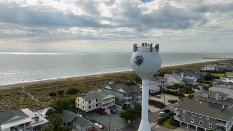 aerial video of flight over hotels at beach and water tower