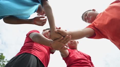 a group of boys reaching out to their friends to show their teamwork