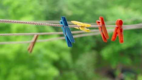 pinzas de ropa de varios colores se balancean en el viento en la cuerda de la ropa.