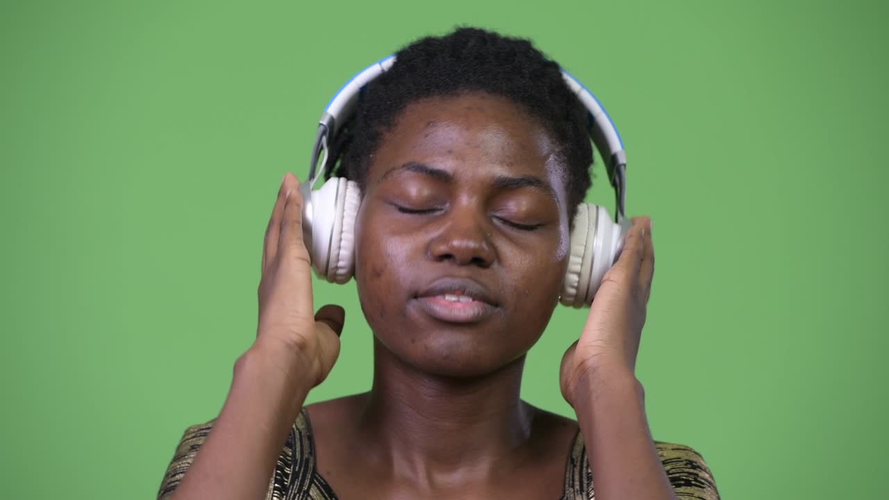 Young beautiful African woman listening to music