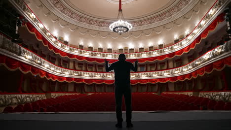 Empty theatre auditorium cinema or conference hall. Actor on stage in front of empty chairs.