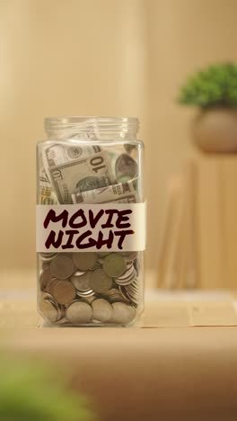 vertical video of person saving money for movie night