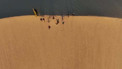 salto de fe - amigos saltan desde la cresta de la duna de arena