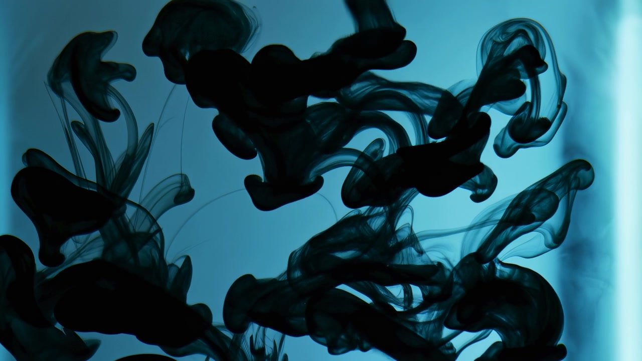 Pennacchi di inchiostro scuro si arricciano e si diffondono attraverso uno sfondo liquido blu vivido, formando morbide tracce organiche, un movimento fluido e una composizione astratta ad alto contrasto.