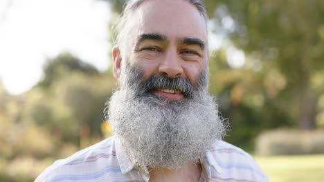 enjoying outdoor park on sunny day, smiling bearded man relaxing